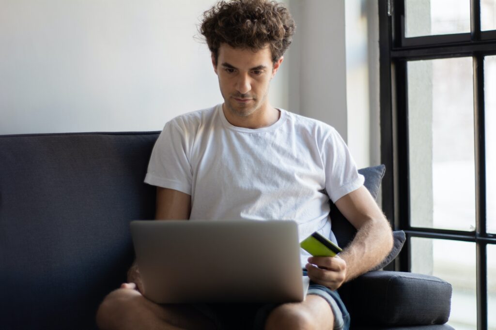 Young man relaxing on the sofa with a laptop